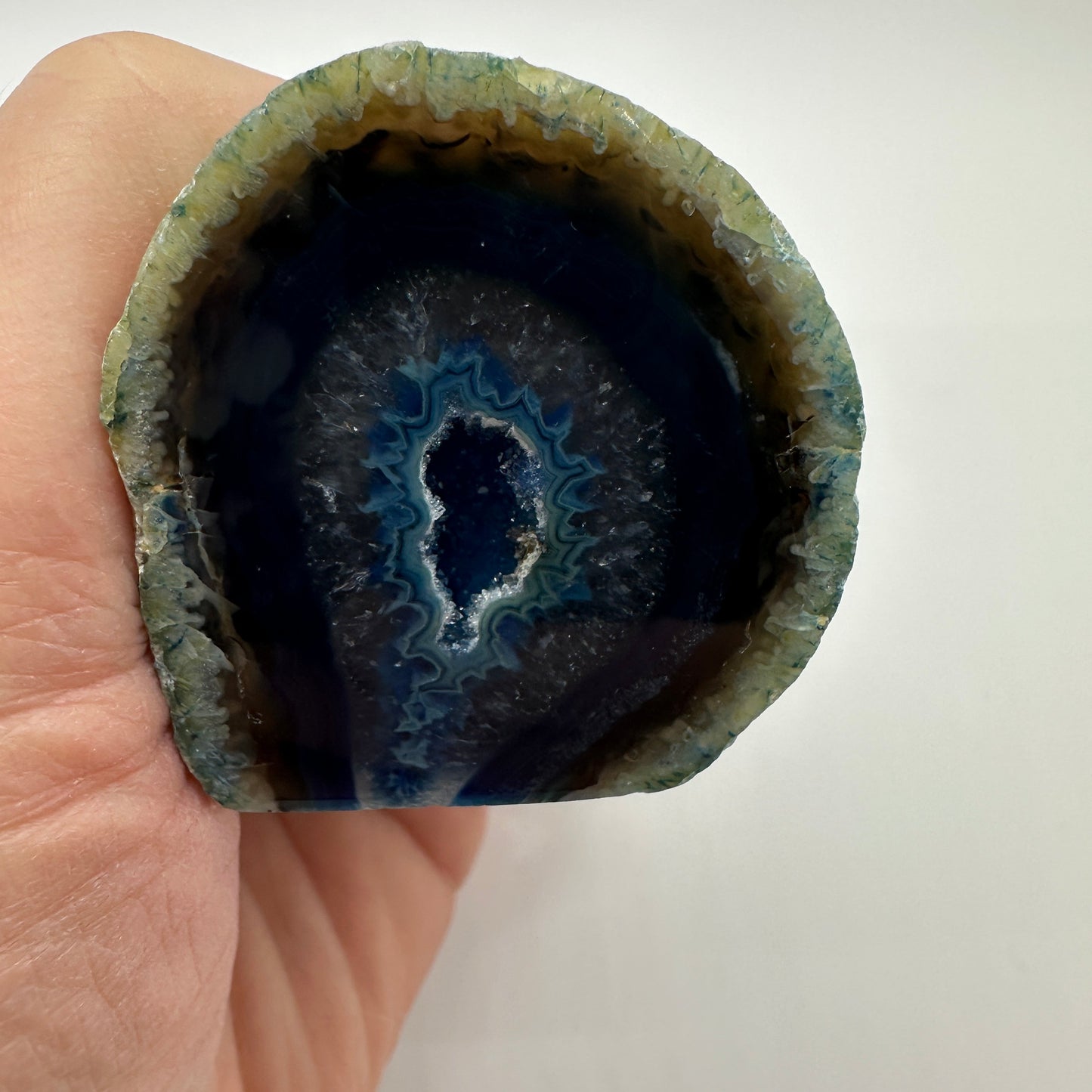 Blue agate geode showcasing its shimmering inner crystals for calm, clarity, and emotional balance