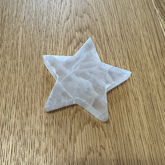 Selenite star crystal with a gentle white glow, symbolising clarity, peace, and uplifting energy
