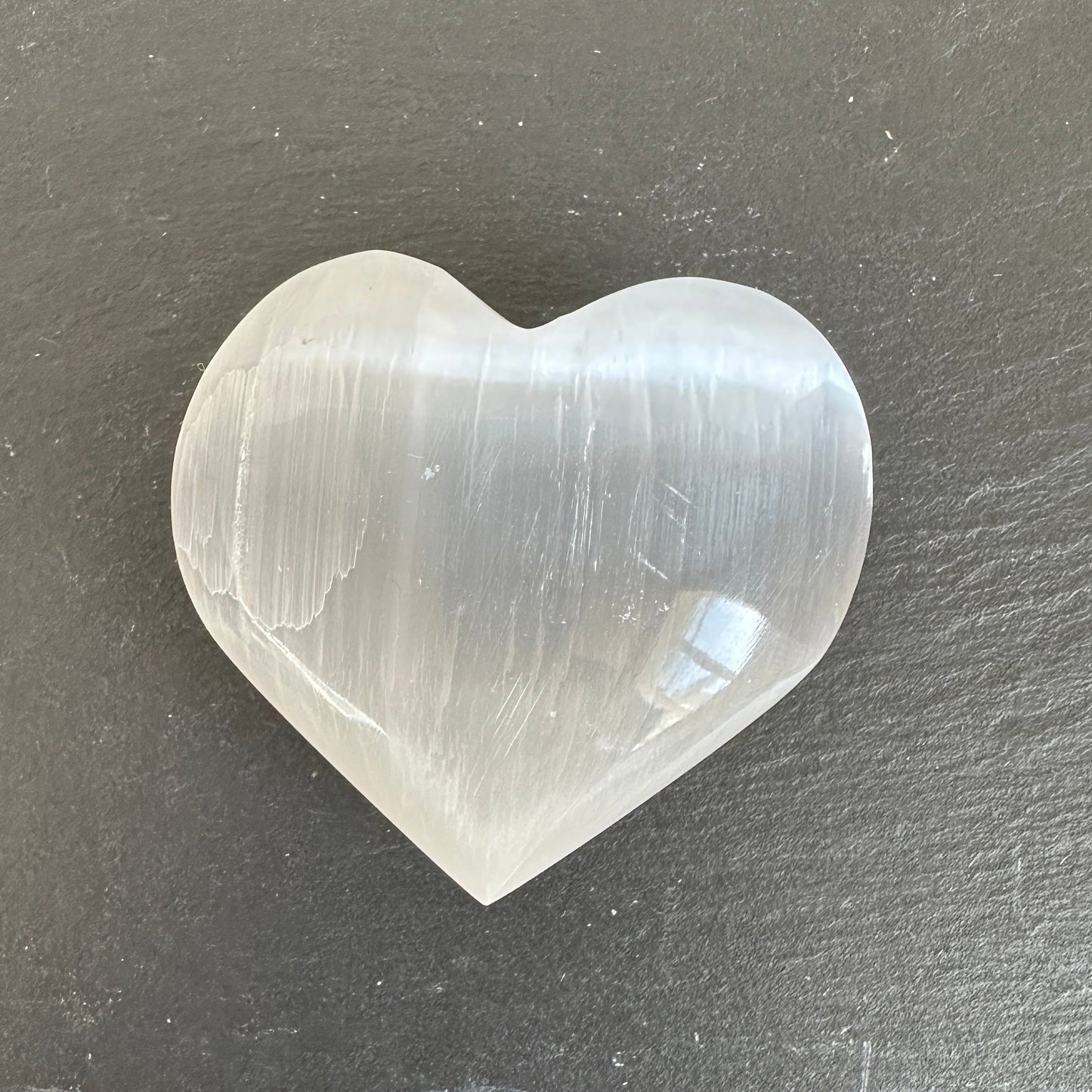 Selenite heart crystal with a soft white glow, symbolising peace, clarity, and gentle emotional cleansing
